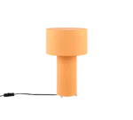 De TRIO Tafellamp Bale heeft een modern ontwerp met een cilindervormige oranje stoffen voet en bijpassende drumkap. Weergegeven tegen een witte achtergrond is het zwarte netsnoer zichtbaar aan de linkerkant.