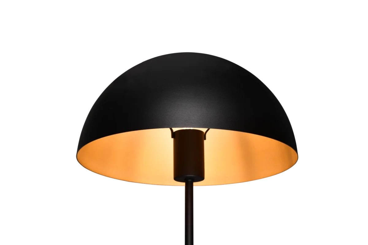 De TRIO Tafellamp Nola heeft een modern ontwerp met een zwarte koepelvormige lampenkap en straalt een zacht warm licht uit tegen een effen zwarte achtergrond.