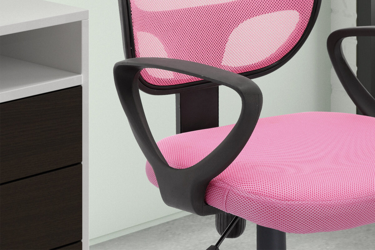 Een close-up van de Bureaustoel 'Hippa' Mesh Roze(1c), een roze mesh bureaustoel met zwarte armleuningen, geplaatst naast een bureau met witte en donkerbruine lades.