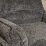 Close-up van de Fauteuil Vera donkergrijze fauteuil, met de pluche bekleding met textuur en een zachte, knusse zitting, armleuning en rugleuning.