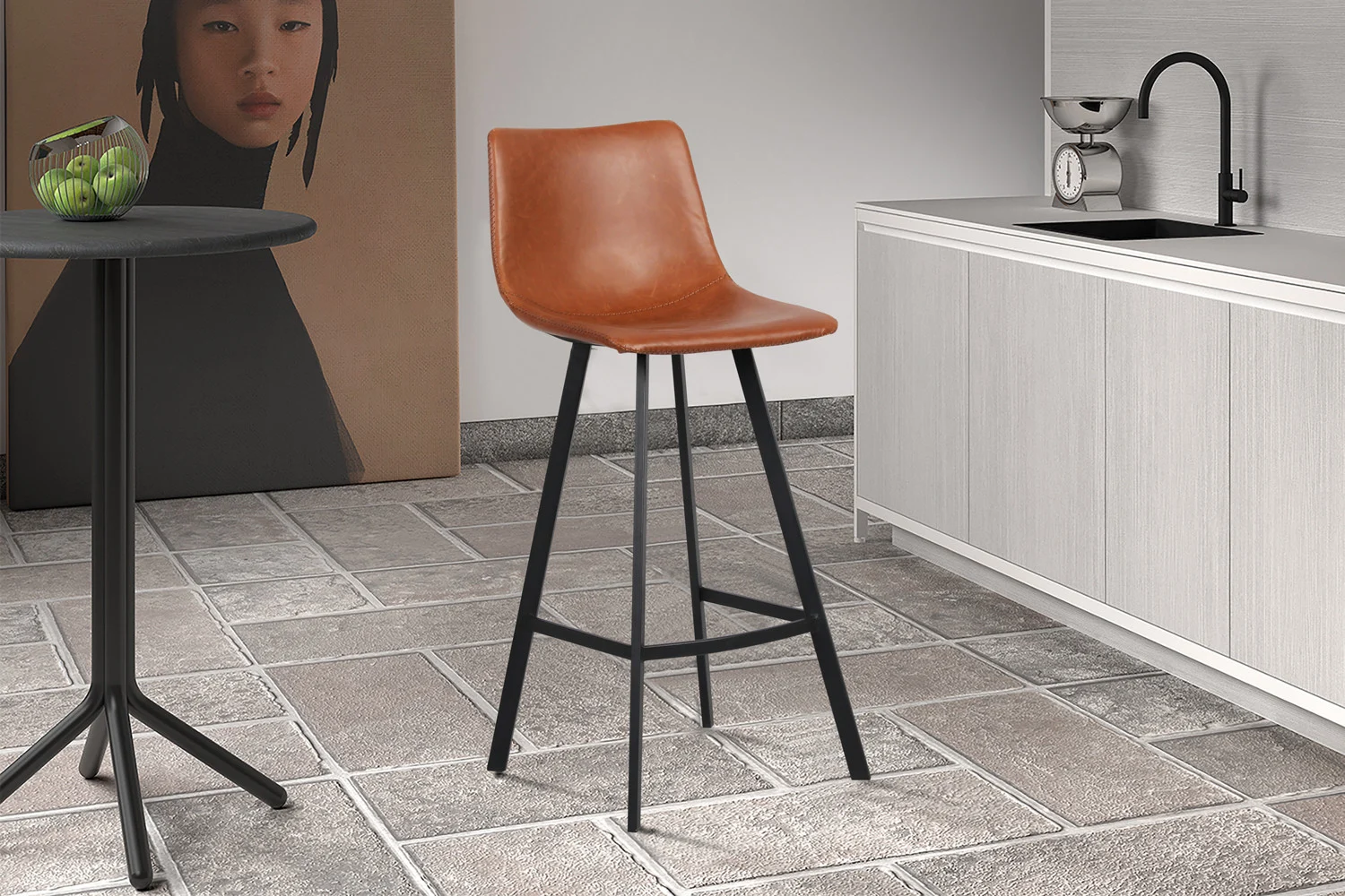 Een moderne keukenscène met Barstoel 'Ozan' PU Cognac (2 per doos), een ronde tafel met groene appels, een gootsteen met kraan en een groot vrouwenportret op de achtergrond op een betegelde vloer.