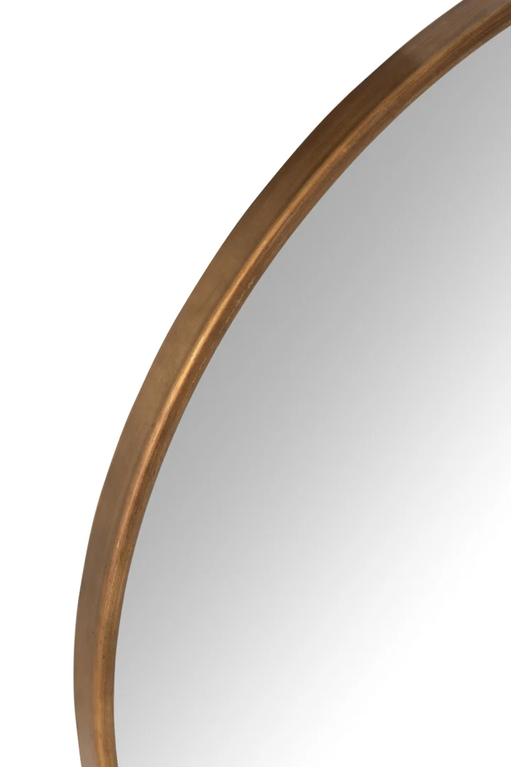 Een close-up van de Mirror Anto MDF/Mirror Gold Large onthult de slanke gouden lijst en het reflecterende oppervlak tegen een witte achtergrond, waarbij slechts een deel van de rand van de spiegel wordt belicht.