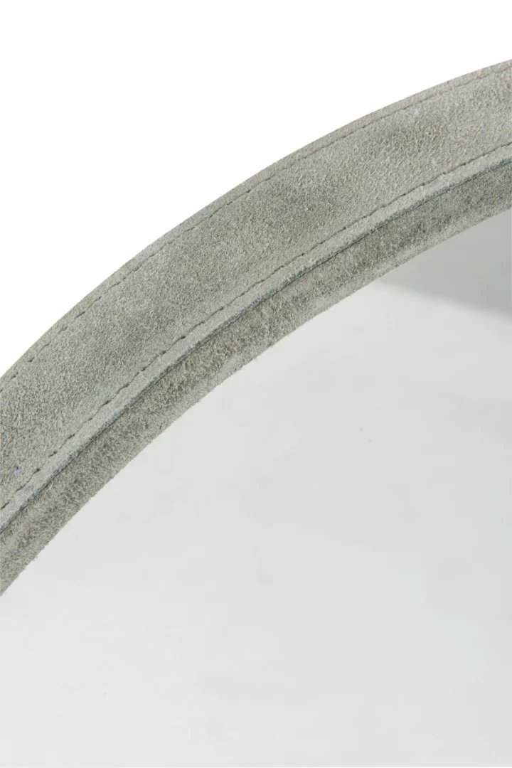 Close-up van de Mirror Round Leather Green Small, met een zacht, leerachtig groen frame met zichtbare textuur en gedetailleerde stiksels langs de rand.