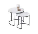 De Mirrors and More Bijzettafel DOREEN set bestaat uit twee ronde nesttafels met witte bladen en zwarte metalen poten; op de grootste tafel staan een glas gelaagde koffie en twee koekjes tegen een witte achtergrond.
