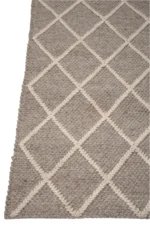 Het Vloerkleed Geruit Wol Beige/Wit heeft een grof geweven structuur in grijs met een verhoogd crèmekleurig ruitpatroon.