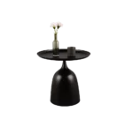 De Mirrors and More Bijzettafel MONA is een ronde zwarte bijzettafel met een brede basis, met daarop een groene glazen vaas met witte bloemen en een klein donker kopje.