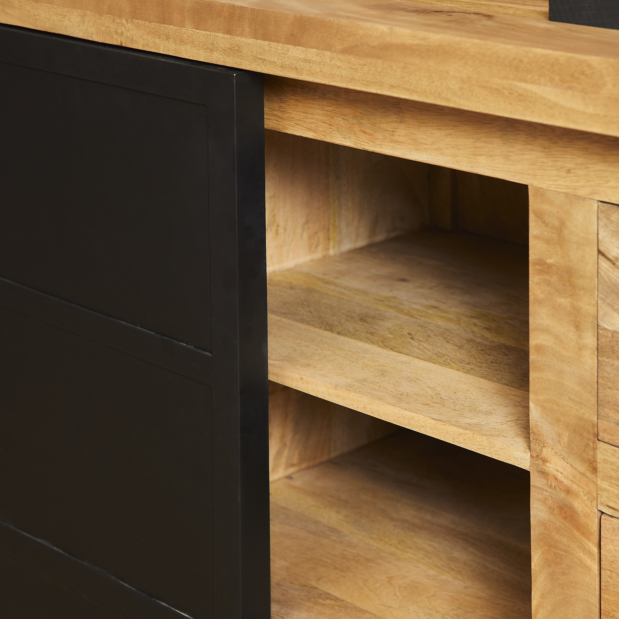 Een close-up van de Nashville Dressoir | 160 cm, met open vakken en een gedeeltelijk gesloten zwarte schuifdeur, die de natuurlijke houtnerf en gladde afwerking benadrukt.