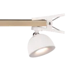 De REALITY Tafellamp MAXIMA, met een wit clip-on ontwerp en geribbelde kap, wordt bevestigd aan een houten balk en werpt het licht naar beneden.
