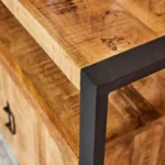 Close-up van de Dressoir Boaz 135 cm met een dik, naturel houten blad, een zwart metalen frame en een houten lade met een zwart handvat onder het tafelblad.