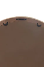 De afbeelding toont de achterkant van de wandspiegel Round Rattan/Glass Natural Small, met een rond houten frame, een bruine kartonnen achterkant en drie zwarte ophanghaken bovenaan.