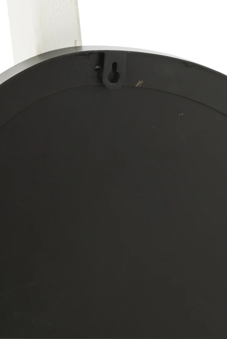 Close-up van de achterkant van de Wandspiegel Extrema Iron/Mirror Black Medium, met een rond zwart oppervlak met een sleutelgat aan de bovenkant voor bevestiging aan de muur. Een wit gedeelte verschijnt gedeeltelijk in de linkerbovenhoek.