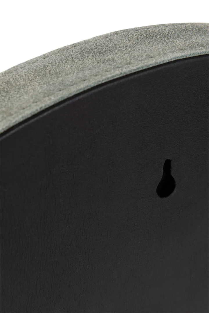 Close-up van de achterkant van de Mirror Round Leather Green Small, met de gestructureerde rand en sleutelgat voor bevestiging aan de muur.