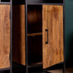 Een close-up van de Boekenkast Oakland | 50 cm toont de houten kast met een zwart metalen frame en een gedeeltelijk open deur die een plank onthult. Het hout heeft een natuurlijke, rustieke afwerking met zichtbare nerfpatronen.