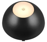 De REALITY Tafellamp RICARDO is een zwarte bolvormige lamp met een gouden ronde bovenkant die in het midden een krachtsymbool weergeeft.
