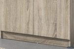 Close-up van het onderste gedeelte van Opbergkast 'Ray' 2 deuren en 4 legplanken Sonoma (1c) met een licht getextureerde houten afwerking, twee deuren en een plint. De vloer is grijs; een klein Rousseau-logo is zichtbaar in de rechterbenedenhoek.