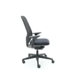 De Workliving Nora Mesh Zwart Regain - Bureaustoel Ergonomisch Design NEN1335 is een moderne zwarte bureaustoel met armleuningen, rugleuning van netweave, zitting met kussens en een onderstel met vijf wielen voor mobiliteit, afgebeeld vanaf de zijkant.