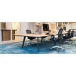 Modern kantoor met een grote houten tafel, computermonitoren, blauw tapijt, glazen wanden en verschillende Workliving Projectas V1 Mesh - Bureaustoel Ergonomisch Design (N)EN 1335 zwarte netstoelen op wieltjes voor een lichte, open sfeer.