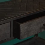 Een close-up van de Sidetable New York | 2 laden, met een donker houten console met een blad met geometrisch patroon en een open lade, tegen een groene achtergrond.