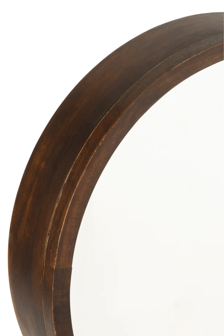 Close-up van het linker bovengedeelte van het Spiegel Schuifwandrek Conie, met een rond ontwerp met een dik, donkerbruin mangohouten frame tegen een witte achtergrond.