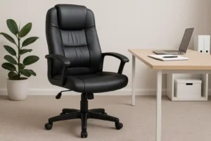 Een zwarte leren bureaustoel-belangrijk voor een bureaustoel- staat naast een licht houten bureau met een laptop, notitieblok en pen. Op de achtergrond voegen een groene potplant en opbergdozen stijl en organisatie toe.