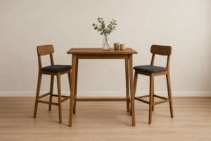 Een minimalistische eetopstelling met een houten tafel van gemiddelde hoogte, twee bijpassende houten stoelen met donkere kussens, een glazen vaas met groen gebladerte en twee beige mokken, allemaal geplaatst op een lichte houten vloer tegen een neutrale muur.