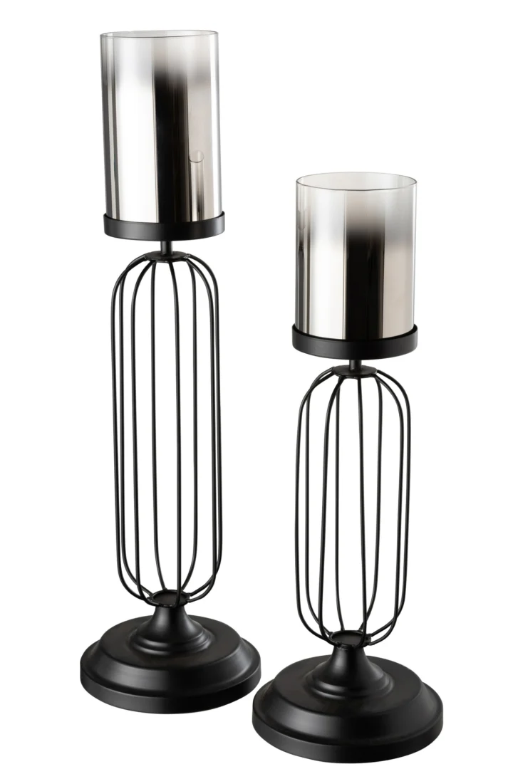De Kaarsenhouder Orkaan Glas Zwart Groot is een hoge kandelaar van zwart metaal met een ronde voet en een open, kooiachtige steel, met daarop een cilindrische glazen stormkap.