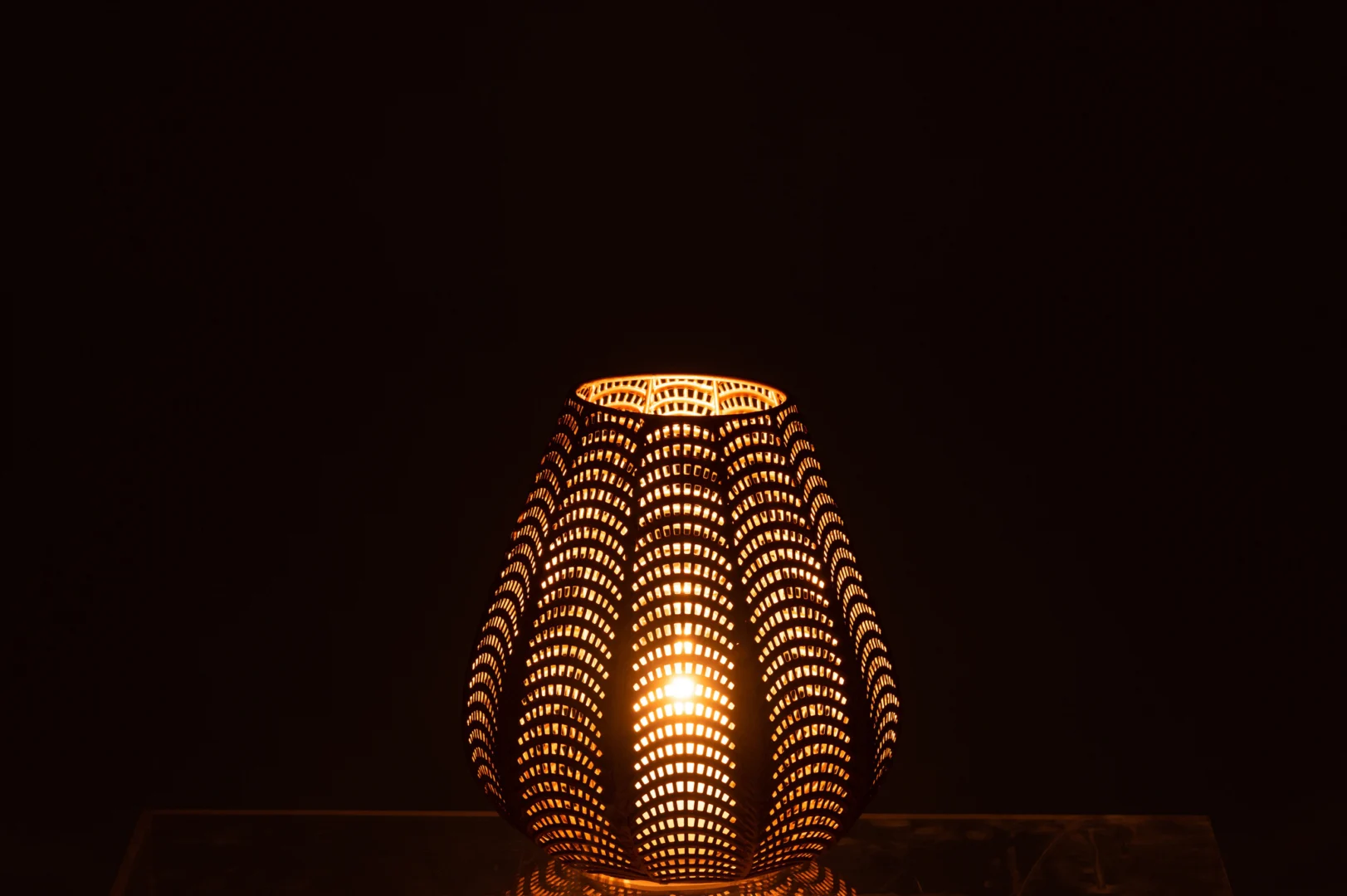 De Kaarsenhouder Gala IJzer Goud Klein heeft een geperforeerd metalen ontwerp dat een warme, zachte gloed uitstraalt en prachtige licht- en schaduweffecten creëert tegen donkere oppervlakken.