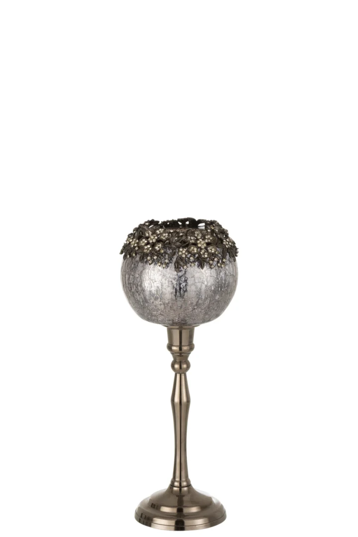 De Theelichthouder Op Voet Juweel Glas Smokey Grijs Groot is een decoratieve kandelaar met een hoge bronskleurige steel en een ronde, gestructureerde rookgrijze glazen schaal met sierlijke bloemenaccenten.