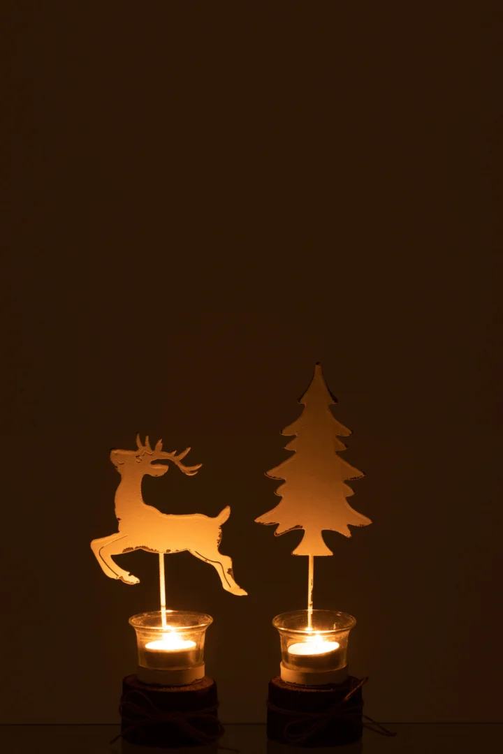 Set van twee "Theelichthouder op boomstam Boom/Rendier" kandelaars - van hout en glas in wit en bruin - met silhouetten van rendieren en dennenbomen die warme schaduwen werpen tegen een donkere achtergrond.