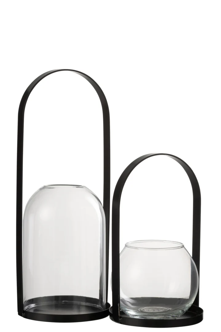 De Kaarsenhouder Orkaan Half Rond Metaal Glas Zwart Groot heeft moderne kandelaars met ronde, heldere glazen kappen, elk op een platte, zwarte, metalen ronde voet en een hoog, gebogen zwart handvat. De ene houder is langer, de andere korter en breder.