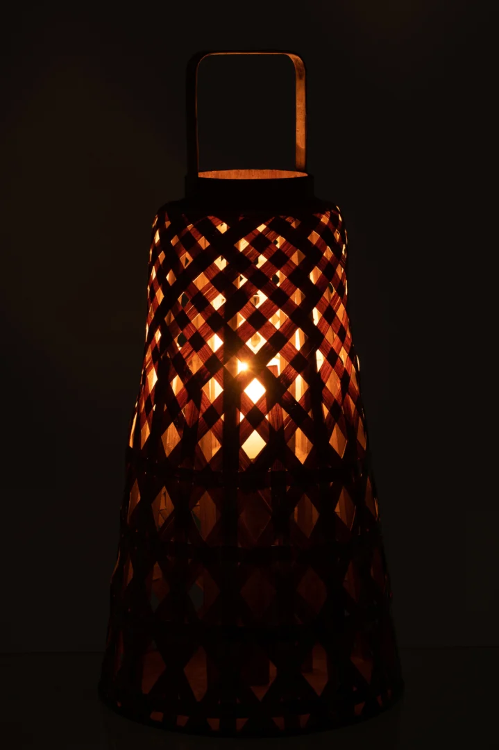 De Lantaarn Bamboe Natuurlijk heeft een kriskras geweven ontwerp, dat warm oranje licht en geometrische schaduwen in het donker werpt.