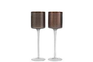 Twee grote "Theelichthouder Op Voet Streep Glas Bruin" kandelaars met slanke heldere stelen en horizontaal gestreepte bruine glazen schalen staan naast elkaar op een witte achtergrond.