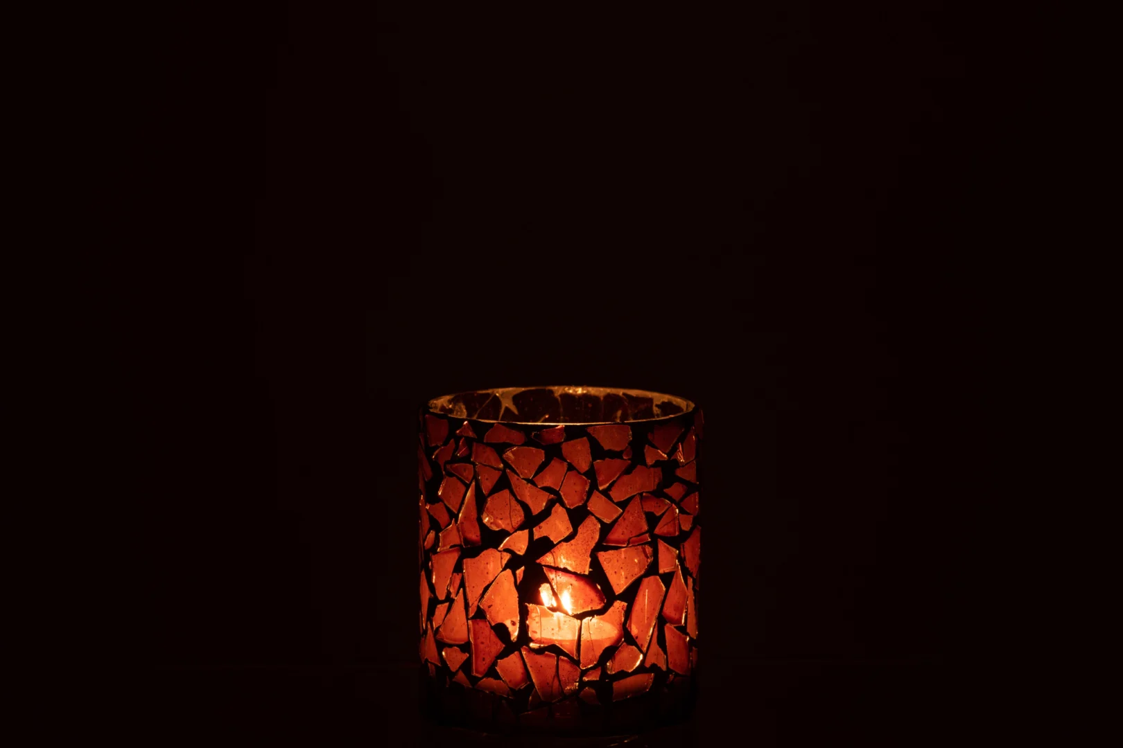 Theelichthouder Mozaïekglas Bruin Klein verspreidt een warme, zachte oranje gloed. De kleine houder van bruin mozaïekglas met onregelmatige, gekleurde stukjes verlicht subtiel elke donkere ruimte.