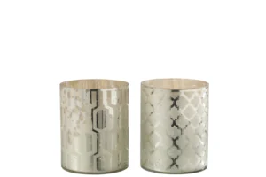 Het Hurricane Glas Zilver Klein Assortiment Van 2 bestaat uit twee glazen kandelaars met metallic zilveren patronen: de ene heeft een geometrisch hexagon en lijnontwerp, de andere een zich herhalende quatrefoil, beide met een reflecterende, gespikkelde afwerking.