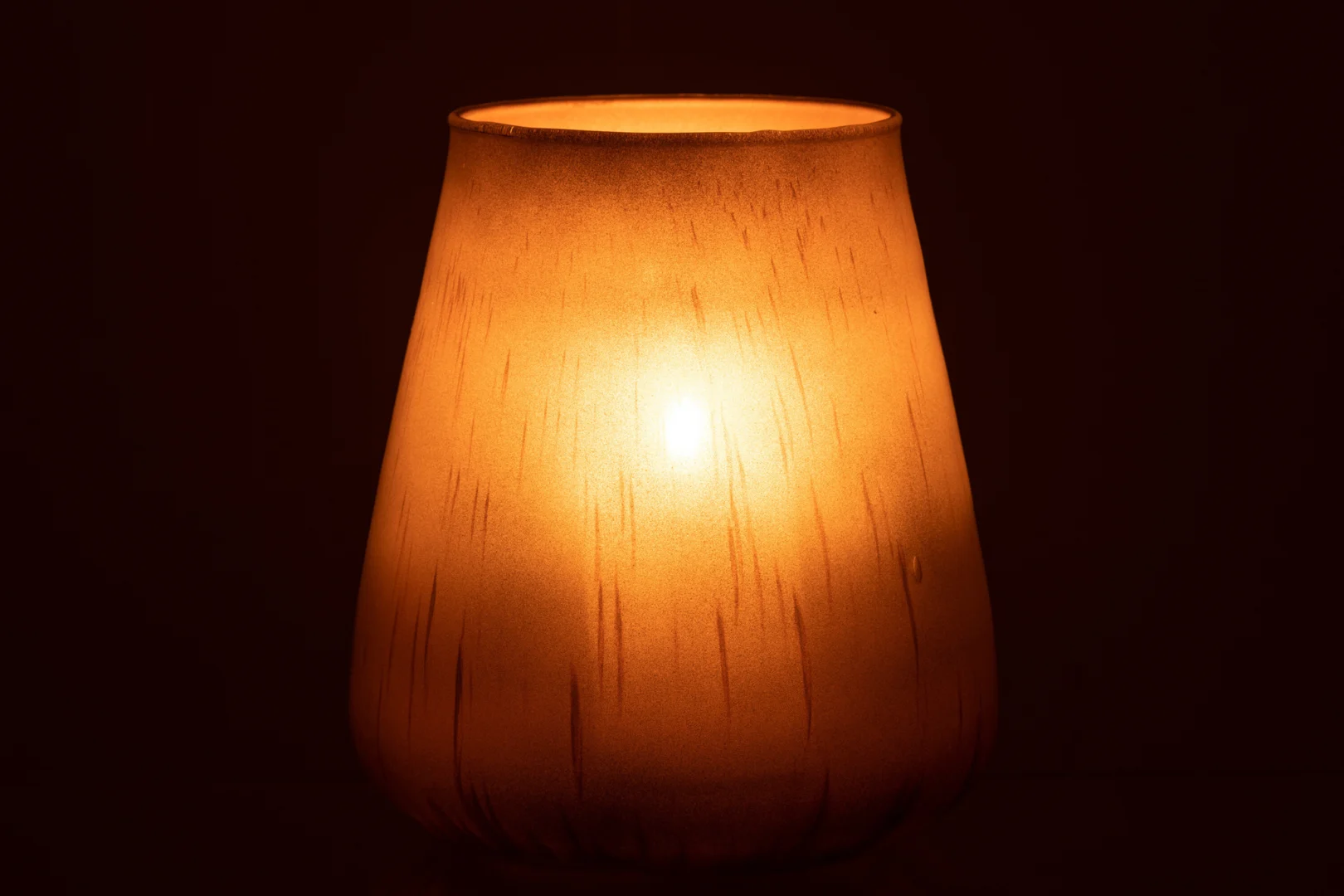 De Kaarsenhouder Hurricane Glas Antiek Bruin Groot werpt een zachte, oranje gloed door het warme, amberbruine matglas en verlicht je ruimte met uitnodigend licht.