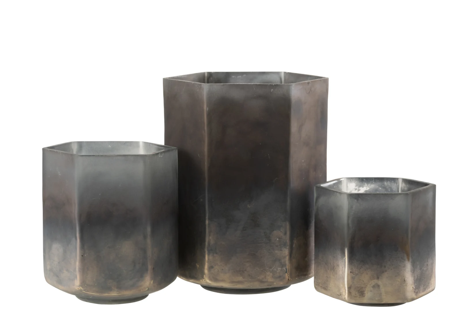 De Kaarsenhouder Orkaan Hexagoon Glas Grijs Groot heeft drie zeshoekige, metalen plantenbakken in verschillende hoogtes met een matte afwerking die verloopt van diepgrijs aan de onderkant naar lichtere tinten aan de bovenkant.
