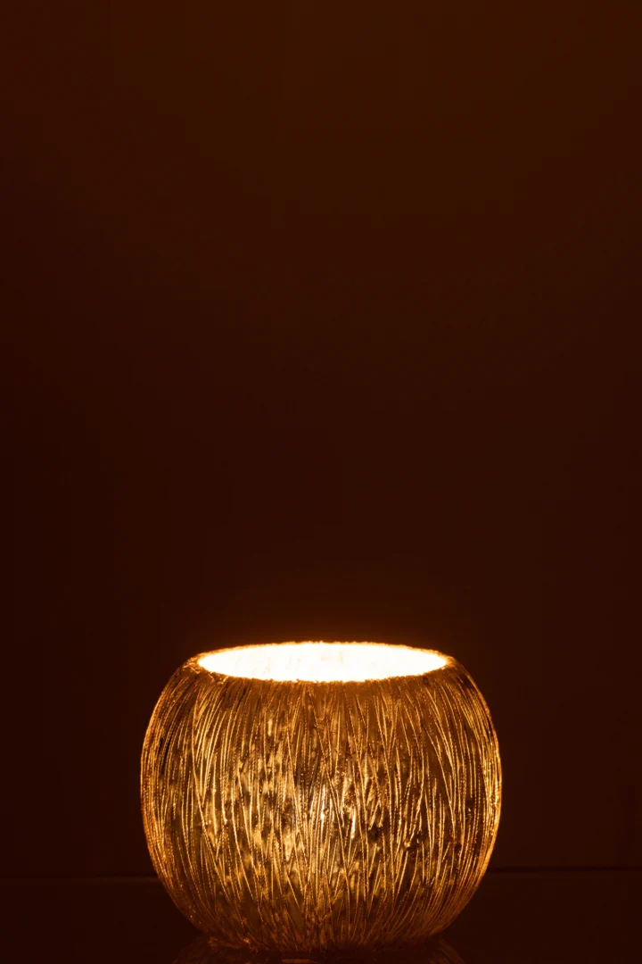 De Kaarsenhouder Orkaan Glas Zilver Klein werpt een zachte, uitnodigende gloed, voegt warmte en gezelligheid toe aan je interieur en steekt elegant af tegen een donkerbruine achtergrond.