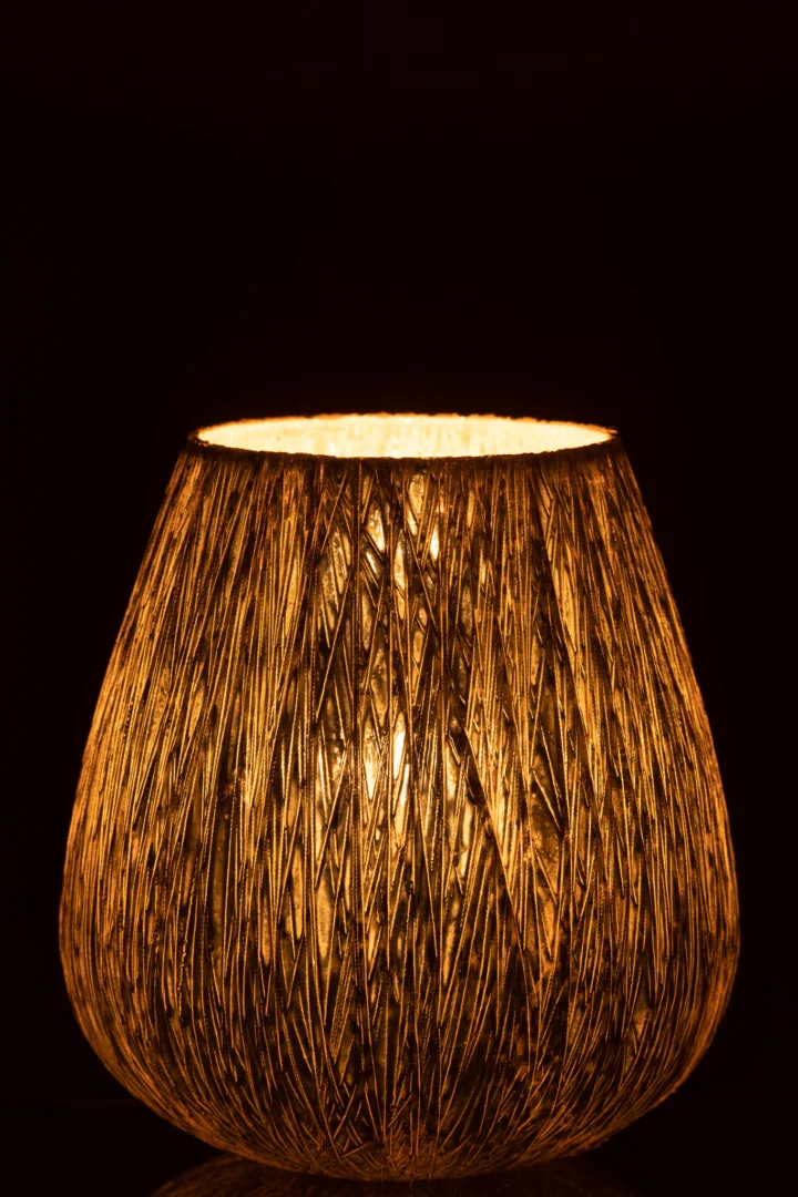 De Hurricane Glas Zilver Middel heeft een geweven, gestructureerd ontwerp dat een warm, goudkleurig licht uitstraalt en een gezellige gloed creëert in een donkere omgeving.