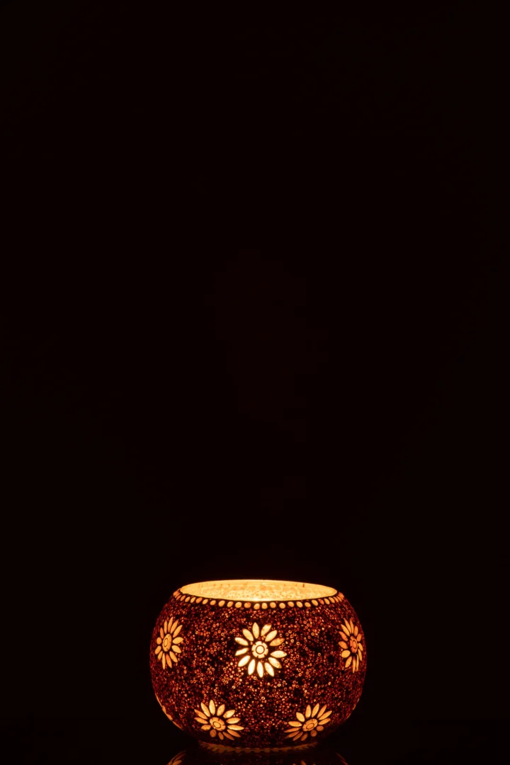 De Kaarsenhouder Bram Glas Gespikkeld Groot is een ronde kandelaar met gespikkelde motieven die warm oplichten in het donker en prachtige lichtpatronen vormen tegen een zwarte achtergrond.