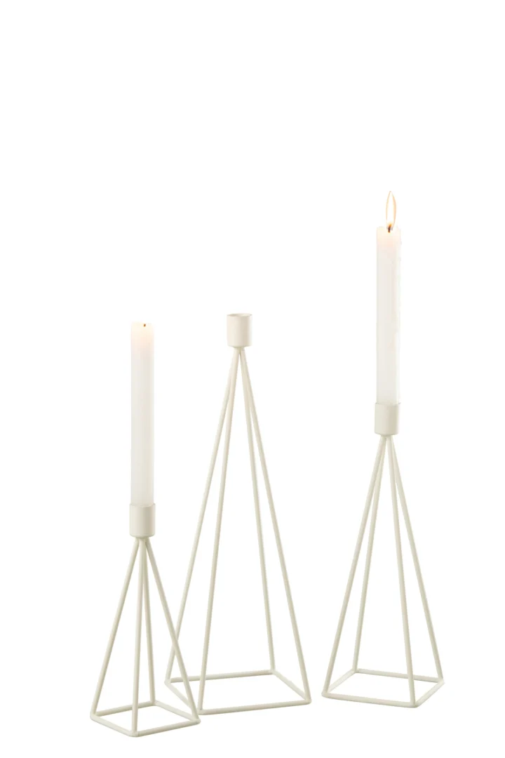 De Kaarsenhouder Metaal Wit Set 3 bestaat uit drie witte geometrische kandelaars van verschillende hoogtes, elk met een witte conische kaars. Twee kaarsen branden en één brandt niet, tegen een effen witte achtergrond.