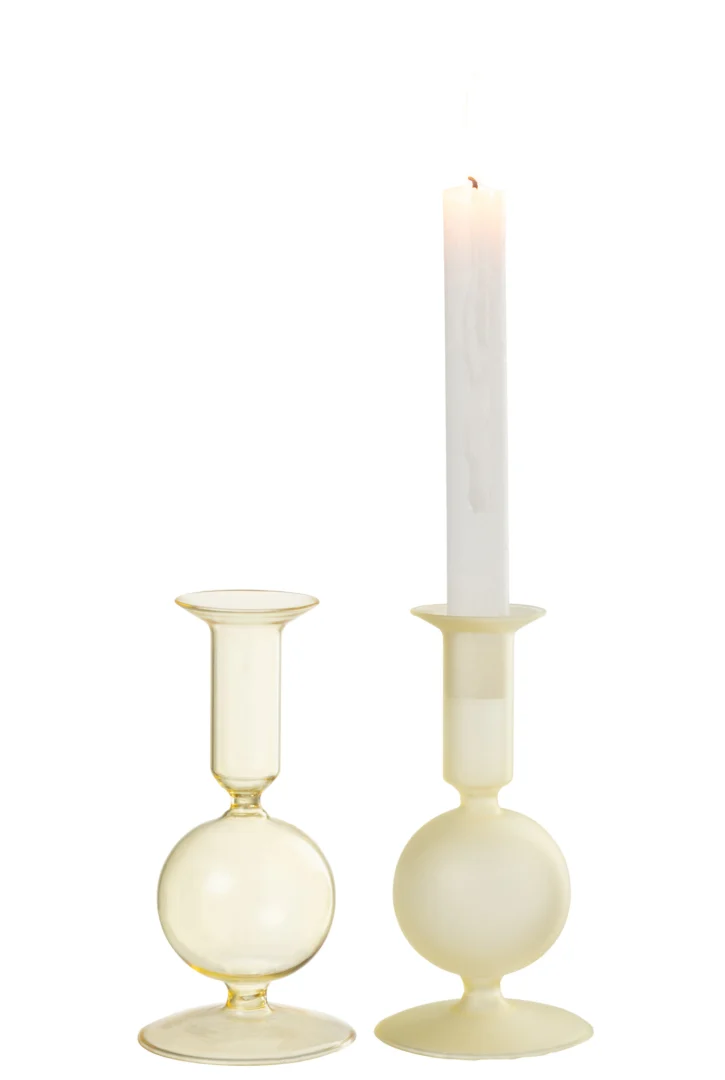 De Kaarsenhouder Orb Glas Lichtgeel Klein Set 2 heeft twee moderne kandelaars van lichtgeel glas met afgeronde voet en uitlopende bovenkant; in de ene houder past een brandende witte conische kaars, terwijl de andere leeg is.
