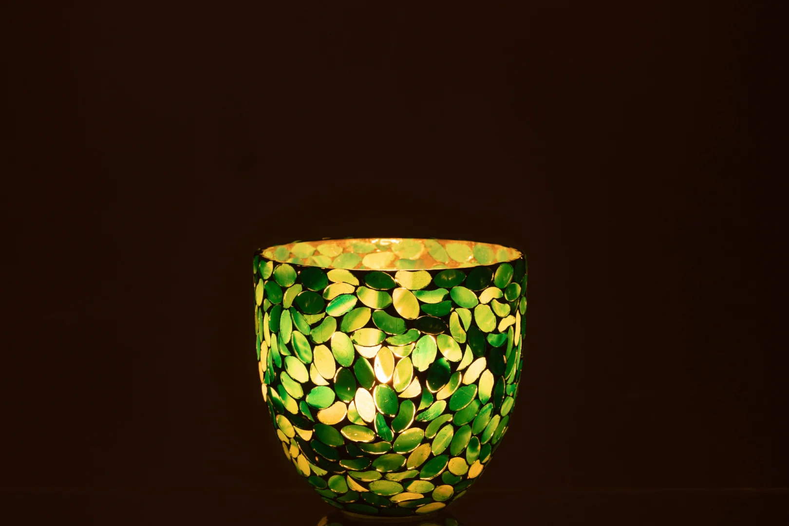 De Kaarsenhouder Orkaan Mozaïek Glas Azuur Middel schittert met blauwe mozaïekglasstukjes tegen een donkerbruine achtergrond.