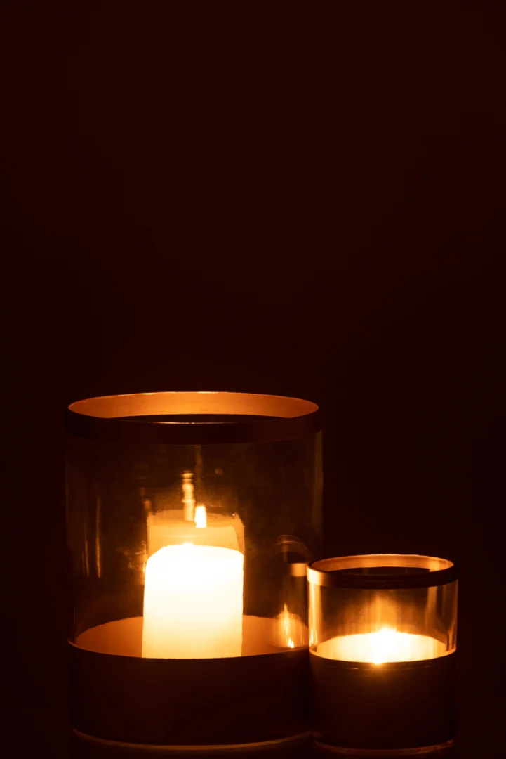 De Kaarsenhouder Orkaan Gouden Lijnen Glas Groot gloeit warm in het donker, het elegante glazen ontwerp creëert een gezellige en vredige sfeer.