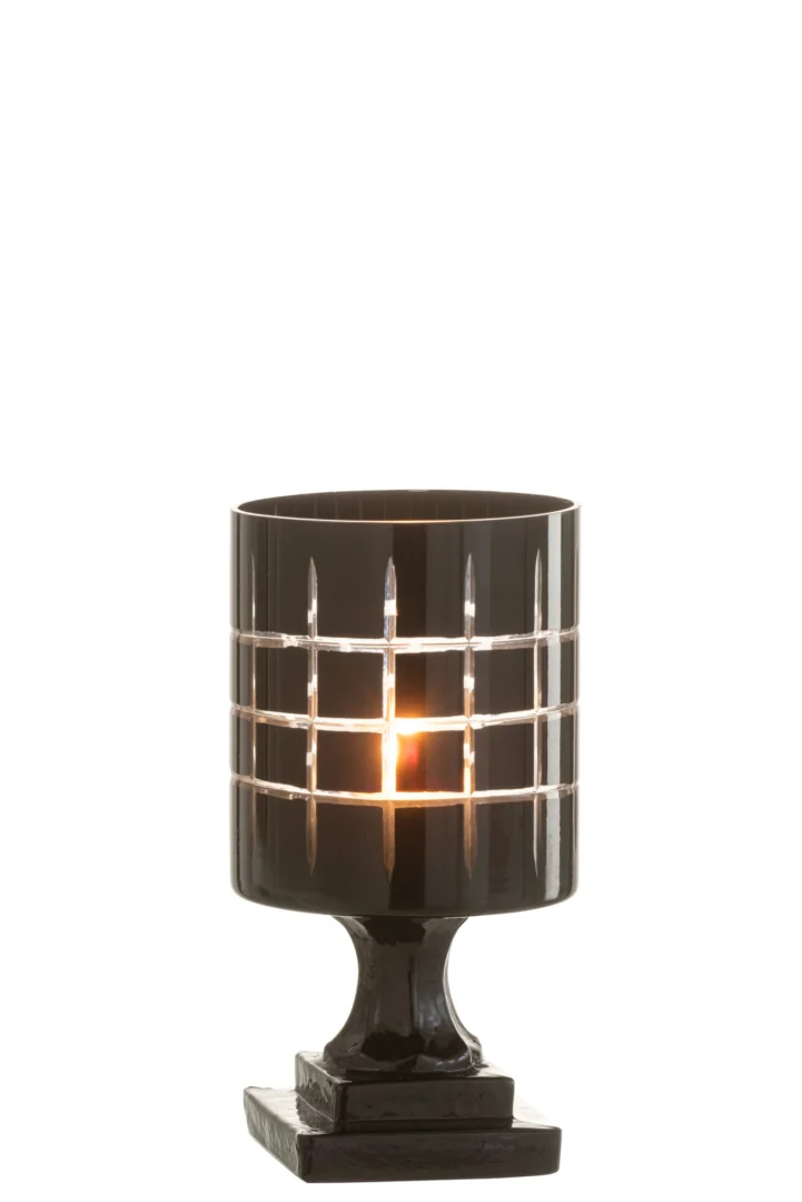 Theelichthouder Op Voet Geruit Glas Zwart: een kandelaar van donker glas met een ruitpatroon, met een brandende kaars erin, staande op een vierkante voet tegen een effen witte achtergrond.