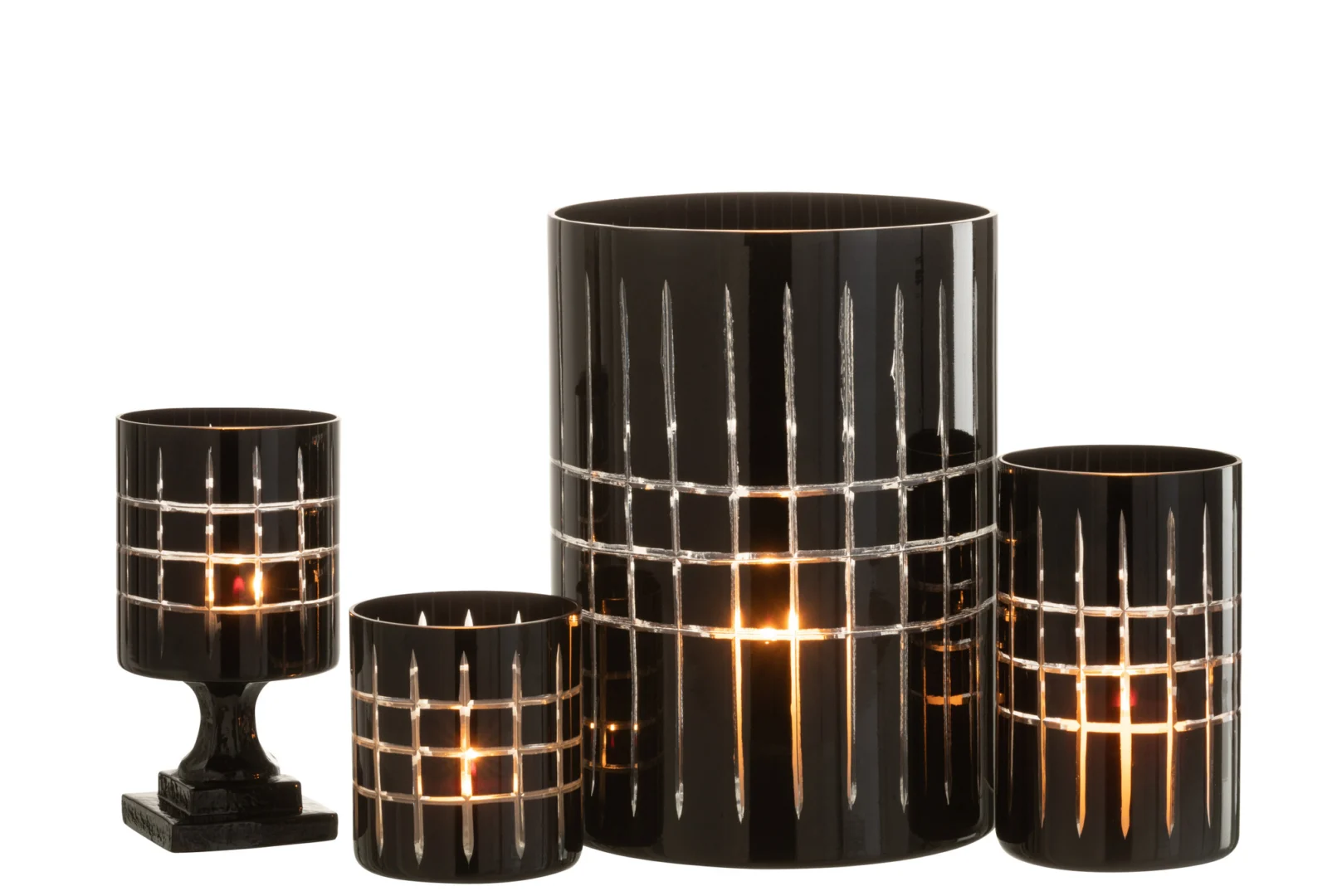 Vier Theelichthouder Op Voet Geruit Glas Zwart kandelaars, in verschillende hoogtes met zwart geruit glas en transparante strepen, elk met een brandende kaars, stralen samen een warme gloed uit tegen een witte achtergrond.