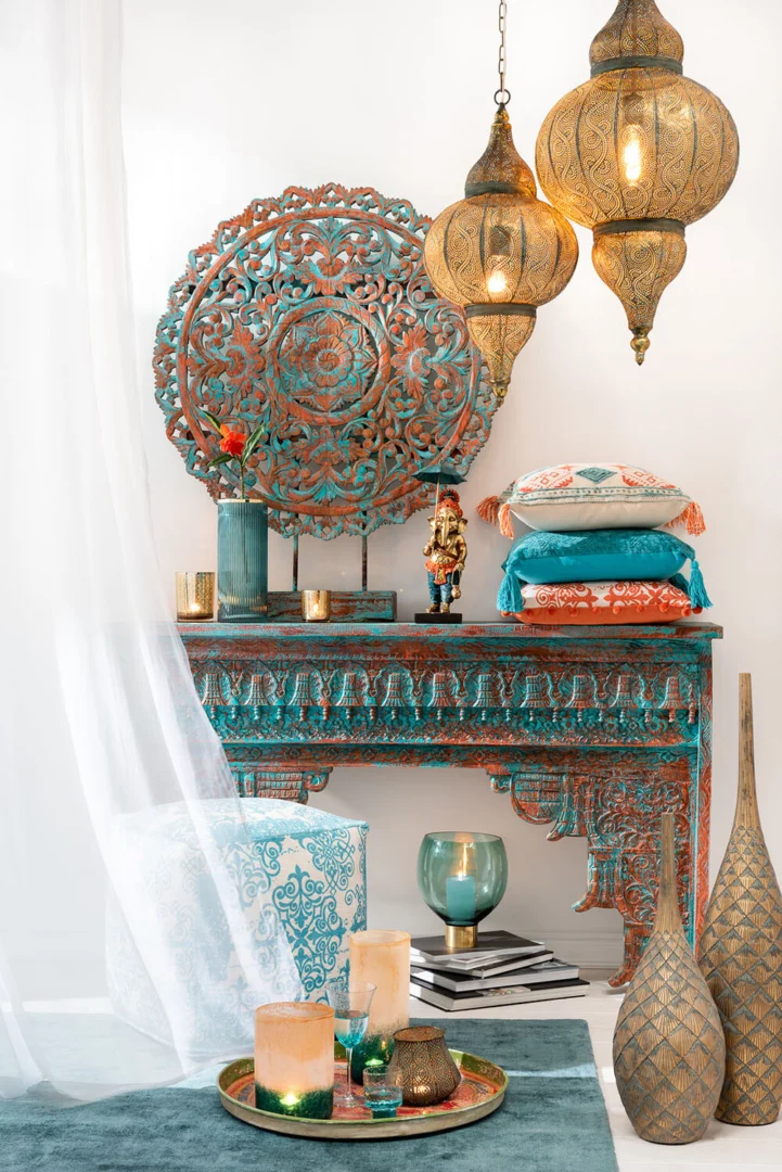 Een Marokkaans geïnspireerde kamer met sierlijke turquoise en roestkleurige meubels, bewerkte muurkunst, hangende koperen lantaarns, kussens met patronen, vazen, een wit gordijn en de Theelichthouder Oosters Metaal Goud Antiek Groot voor een gezellige exotische sfeer.