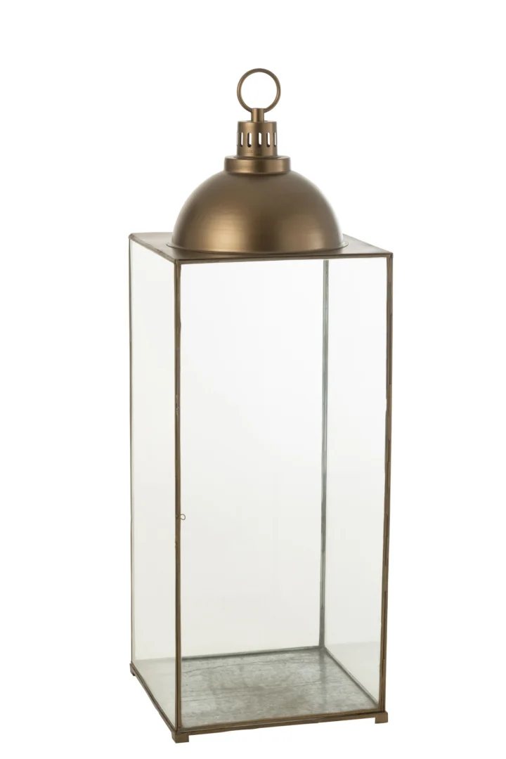 De Lantaarn Hagrid Glas IJzer Brons Large is een rechthoekige glazen lantaarn met een brons metalen frame, een koepelvormige bovenkant en een rond handvat om hem te dragen of op te hangen. De lantaarn is leeg van binnen.