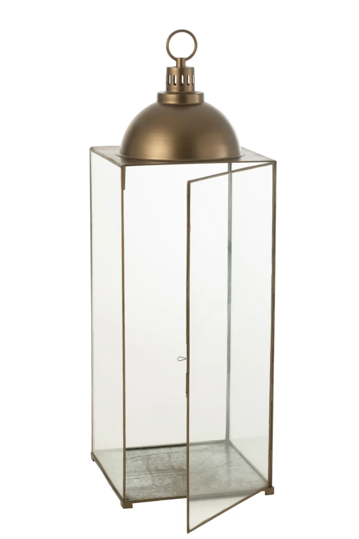 De Lantaarn Hagrid Glas IJzer Brons Large is een rechthoekige glazen lantaarn met een metallic bronzen koepelvormige bovenkant, een ronde handgreep en een scharnierende glazen deur aan de voorkant.