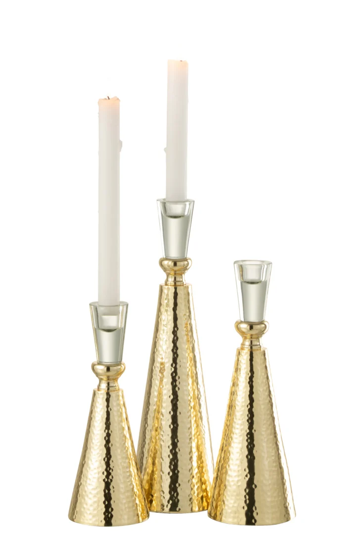 De Kaarsenhouder Tape Aluminium Glas Goud Groot heeft gouden, gehamerde metalen houders van verschillende hoogtes met glanzende, reflecterende afwerkingen en accenten van helder glas. Twee witte conische kaarsen branden en benadrukken het elegante ontwerp.