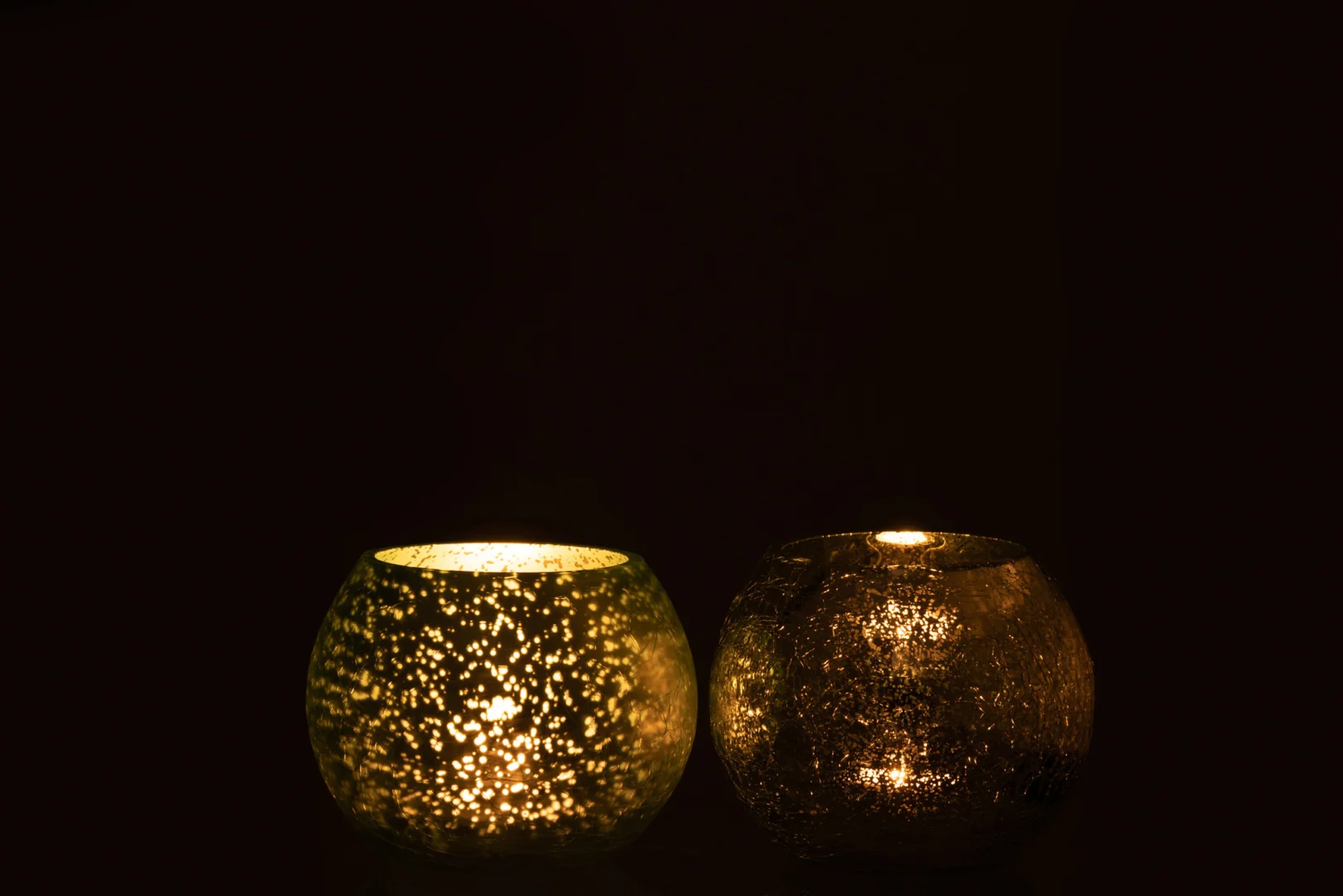 Theelichthouder Sphere Craquelure Glas Aqua Groen Klein Set 2 werpt een zachte, warme gloed in het donker, als de houders van gestructureerd glas met brandende kaarsen sprankelende patronen creëren door hun ingewikkelde craquelureontwerp.